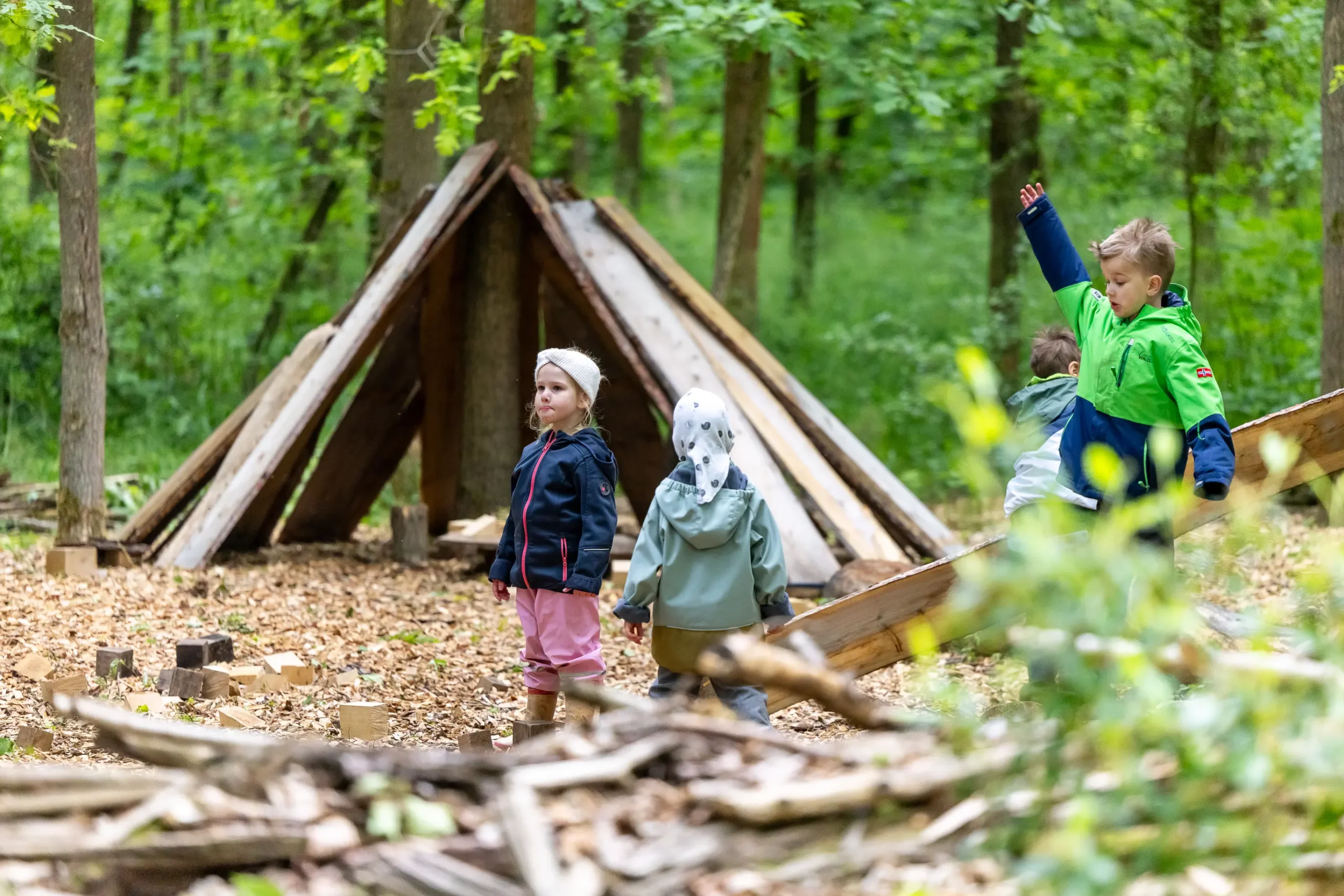 Kinder toben auf dem Waldplatz